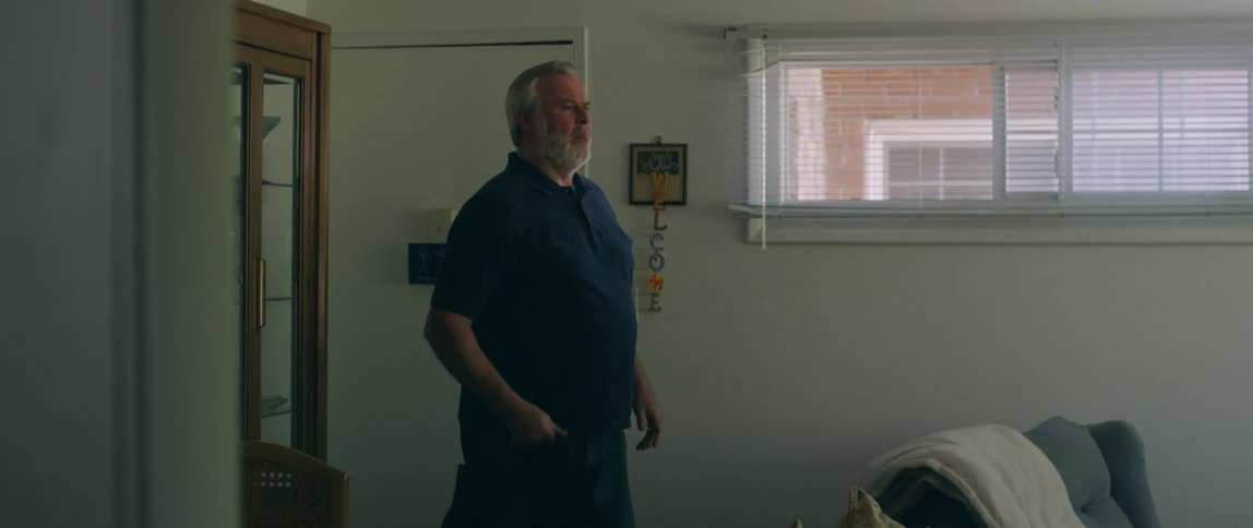 Man takes off his coat and throws it on a chair