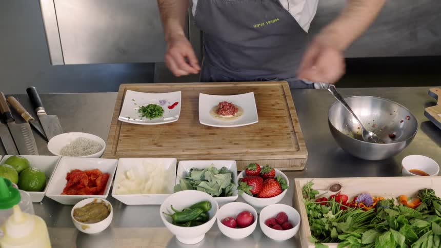 A man places garnish on a plate of food