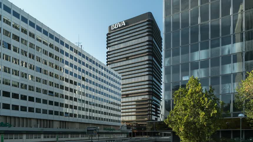 Office buildings stand tall in the city under a blue sky