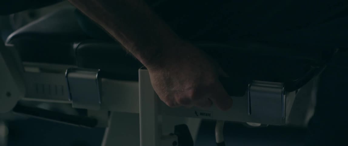Hand holds tightly onto the edge of a chair
