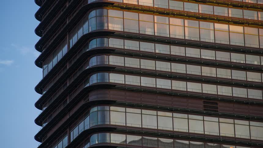 Clouds move past and reflect on the windows of a building