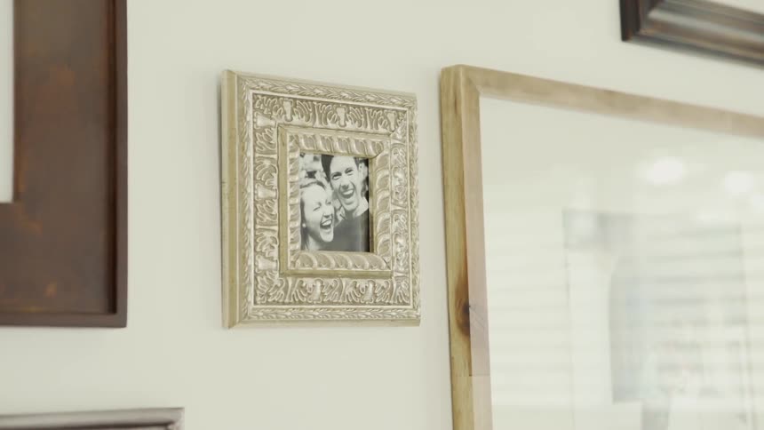 Framed photographs hang on a white wall