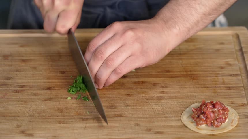 A man is cutting some food on a board