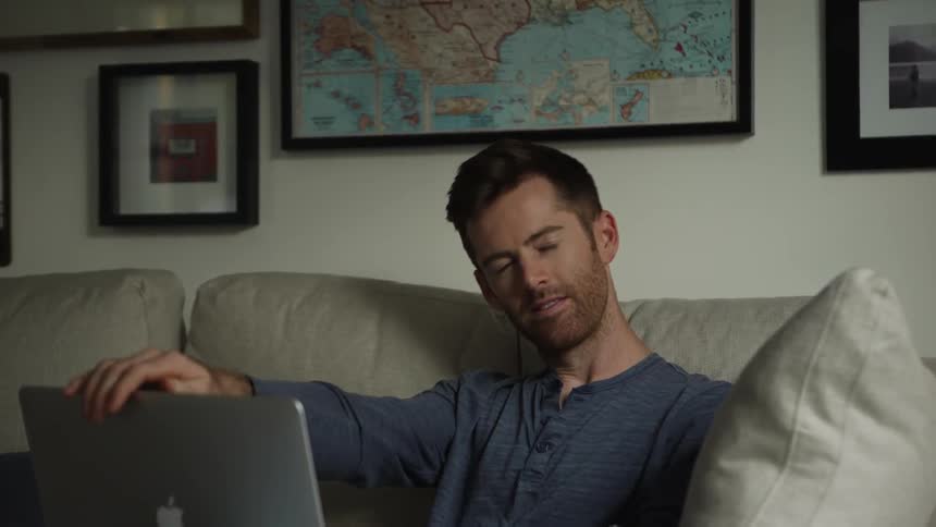 Man Closes His Laptop and Looks and Smiles