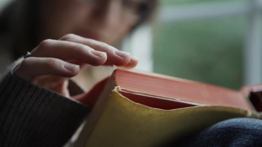 Woman turns the page of a book