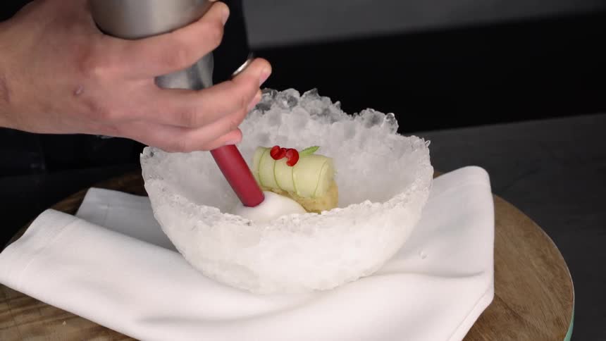 A person is putting cream in a dish