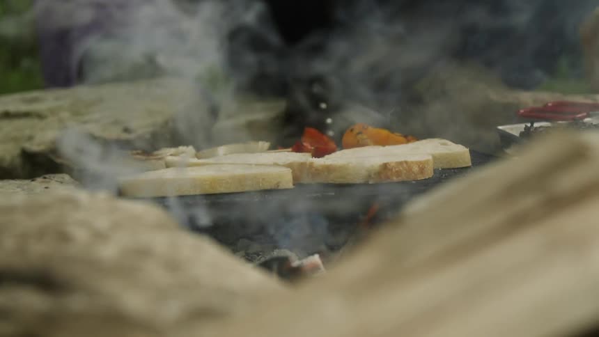 Food cooks on a grill over a hot fire