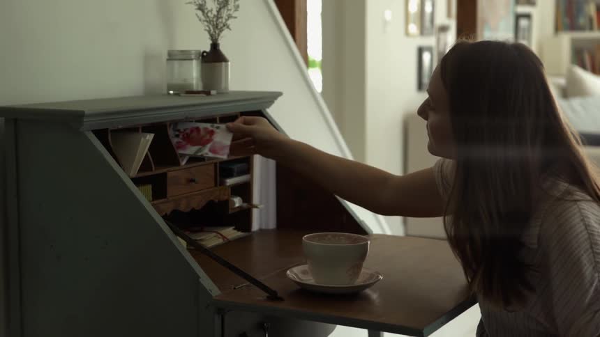 Woman Searches for Stationary in Old Writing Desk