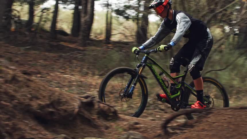 A man rides a mountain bike on a dirt trail in the woods