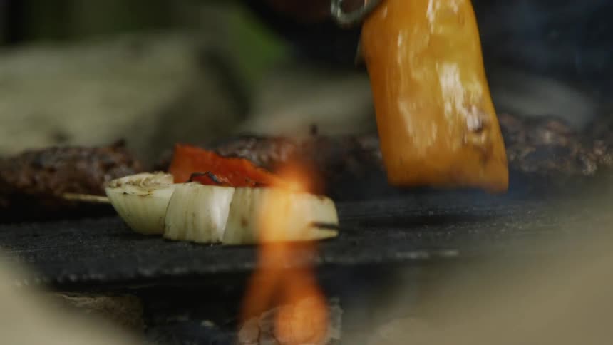 Tongs flip food over on a grill