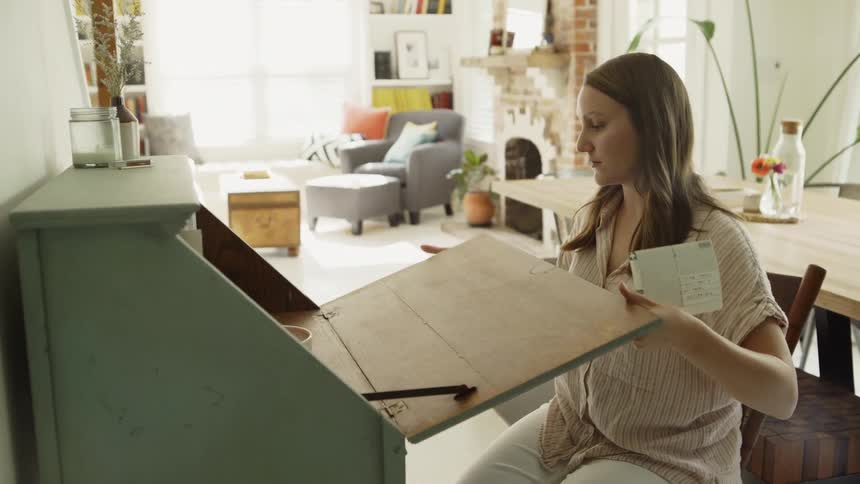 A woman pulls down the lid of a desk