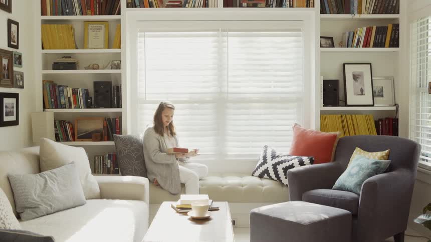 The woman sits down carrying a large book