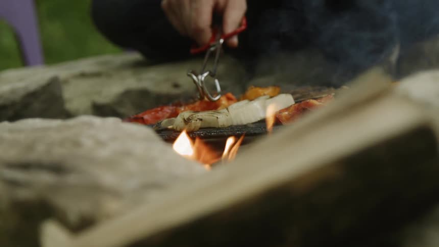 The fire is rising as the food is flipped on the grill