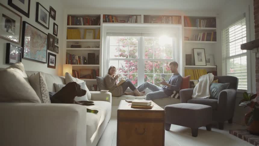 The man and woman sit together on the windowsill