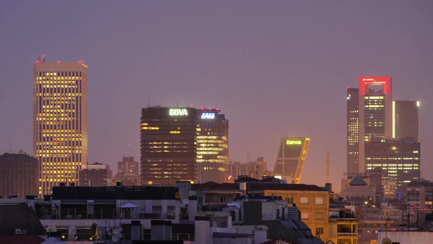 Sun sets over a brightly lit city