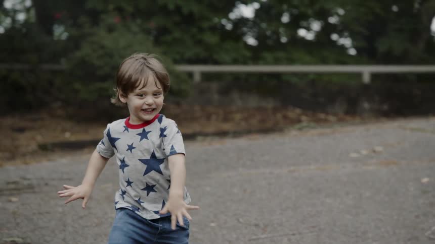 A boy laughs as he runs
