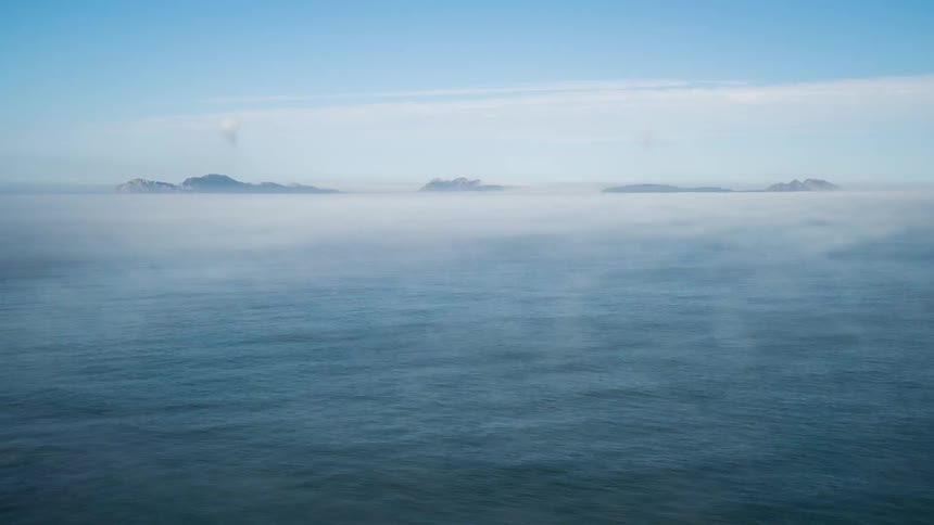 The water is covered with light fog
