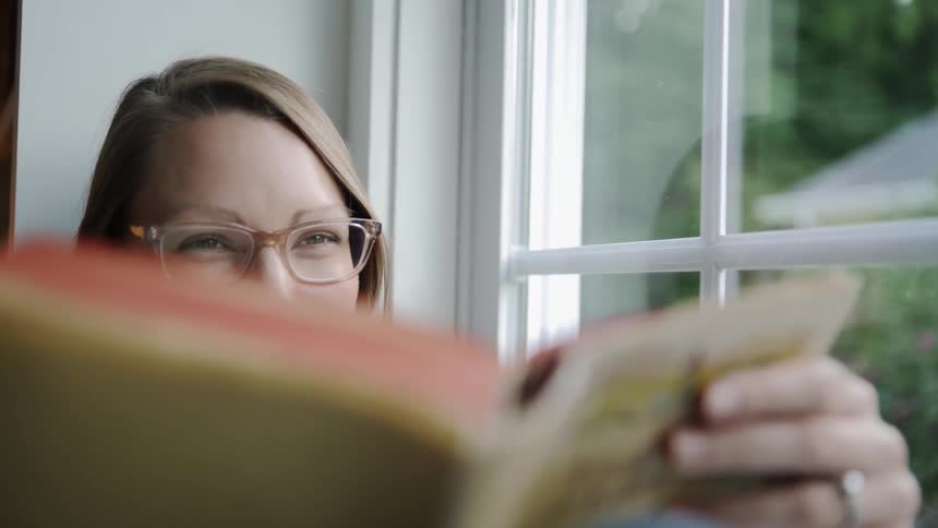 Woman smiles as she reads a book
