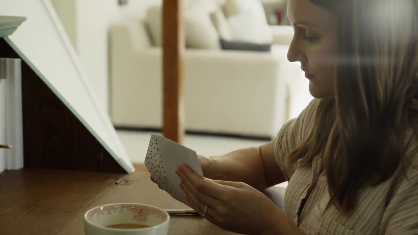 A woman closes the envelope on the card