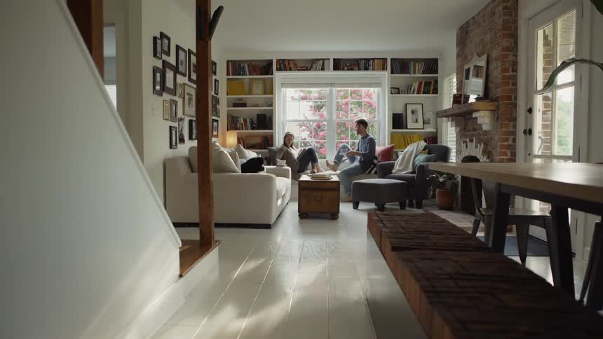 Man sits on a chair and talks to the woman sitting on the sofa