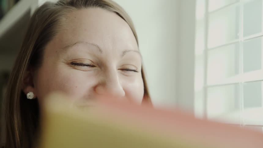 Woman Reads and Smiles