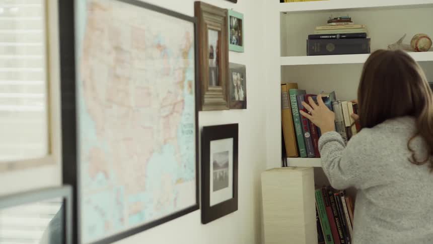 Woman Looking at Books on a Shelf