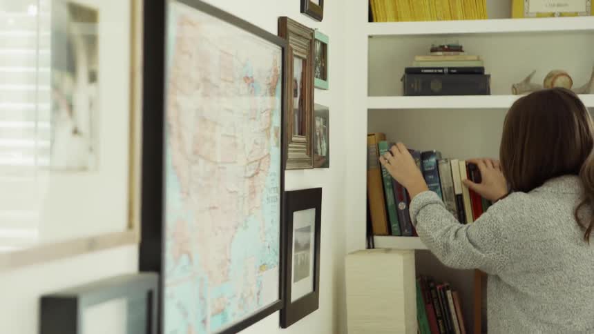 A woman looks at books on a shelf