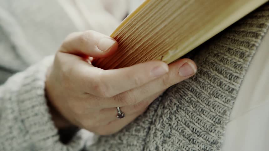 A woman holds a book in her lap