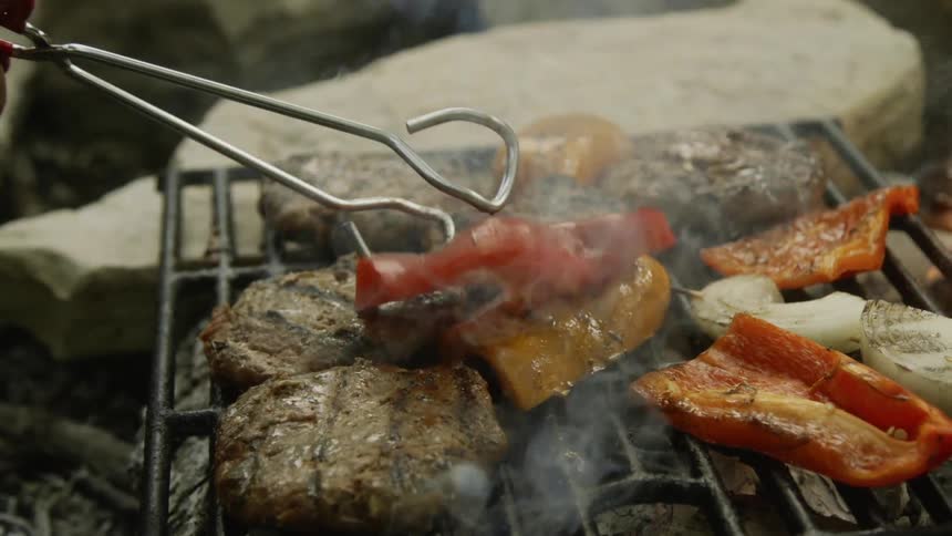 The person flips a pepper on the hot grill