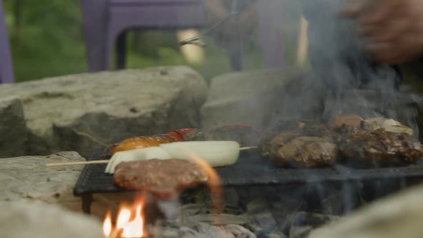 The fire is cooking the food on the grill as it is flipped