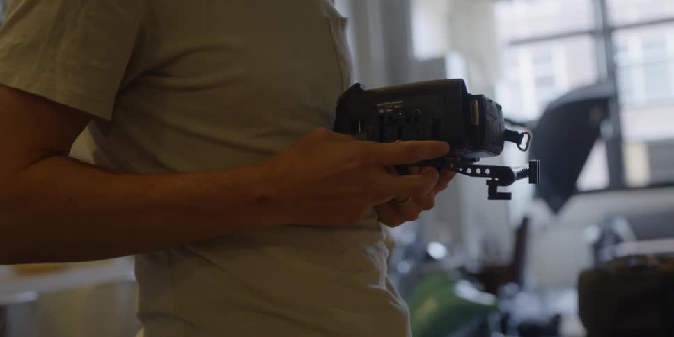 A man holds equipment and puts it together