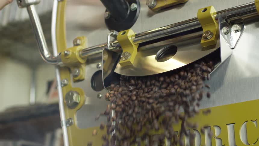 A machine pouring a large number of coffee beans out