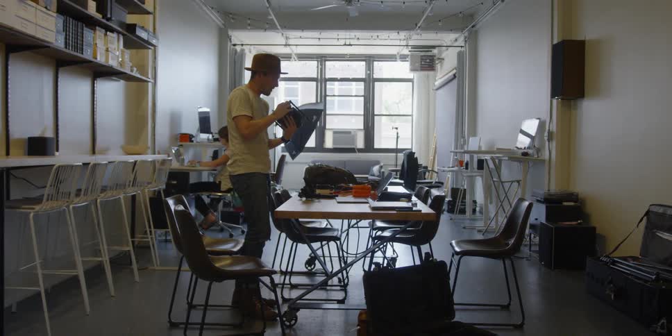 Man stands in a classroom turning an object over