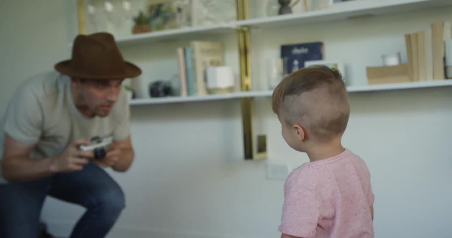 The man takes a picture of a child