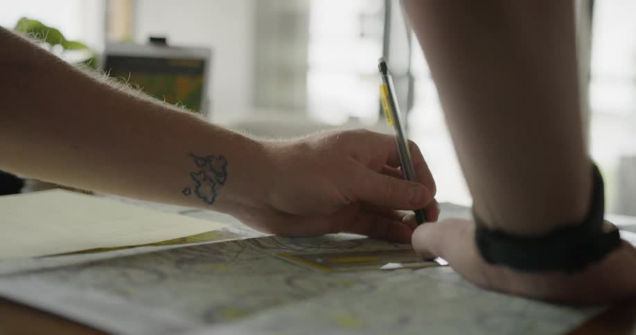 A man draws on a map at a desk