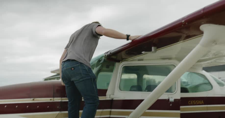 A man checks the wing of a small airplane