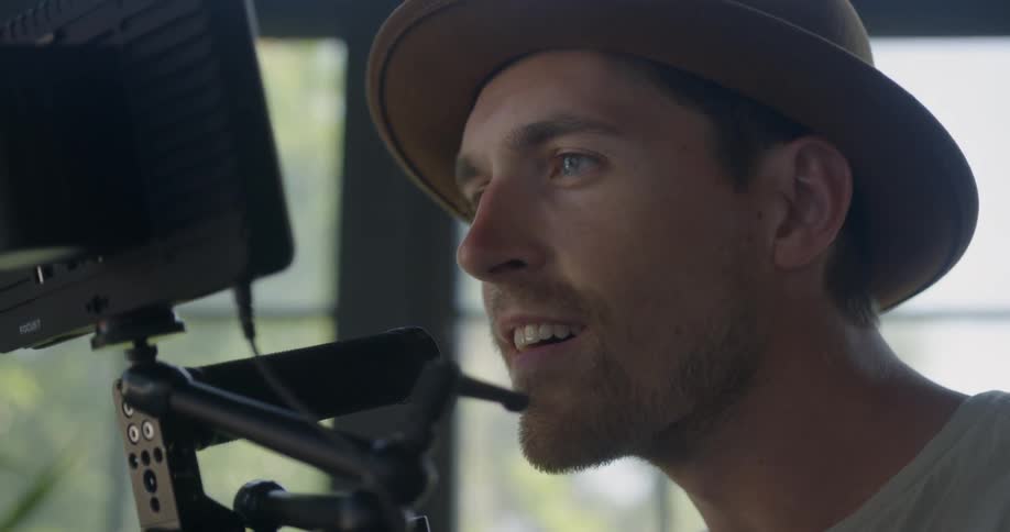 The man is smiling as he films