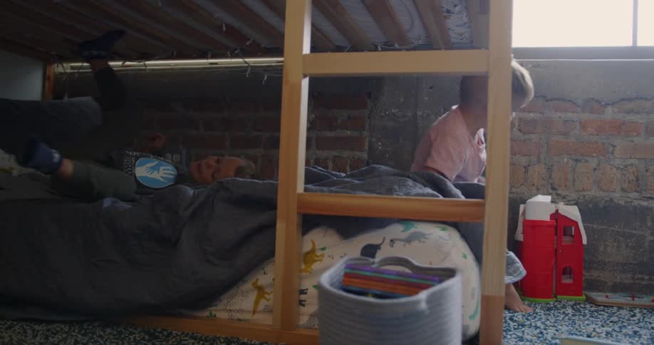 Brothers play on the bottom bunk of bunk beds