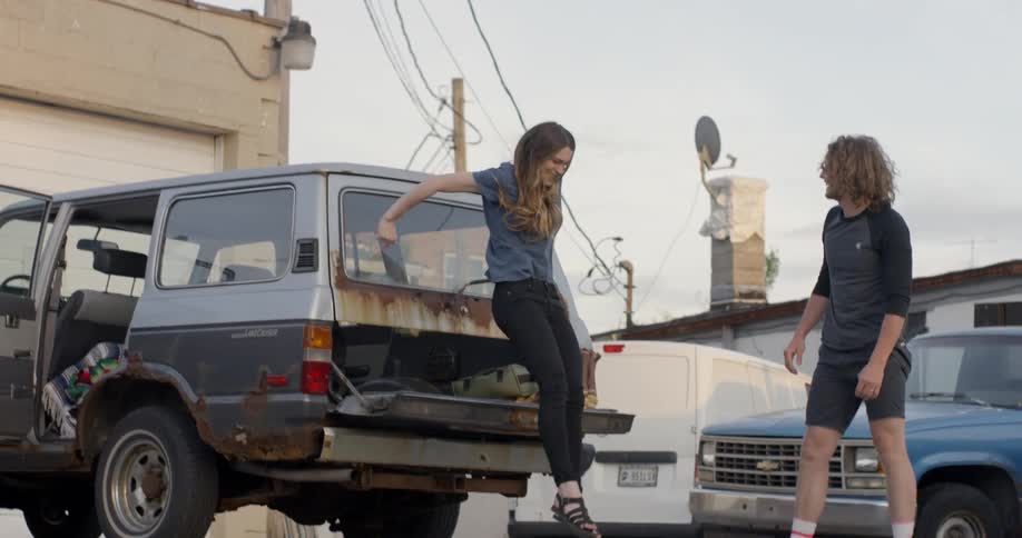 A woman jumps down from a truck roof