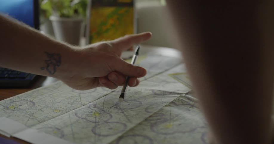 Man scrolls on a tablet then erases something on a diagram