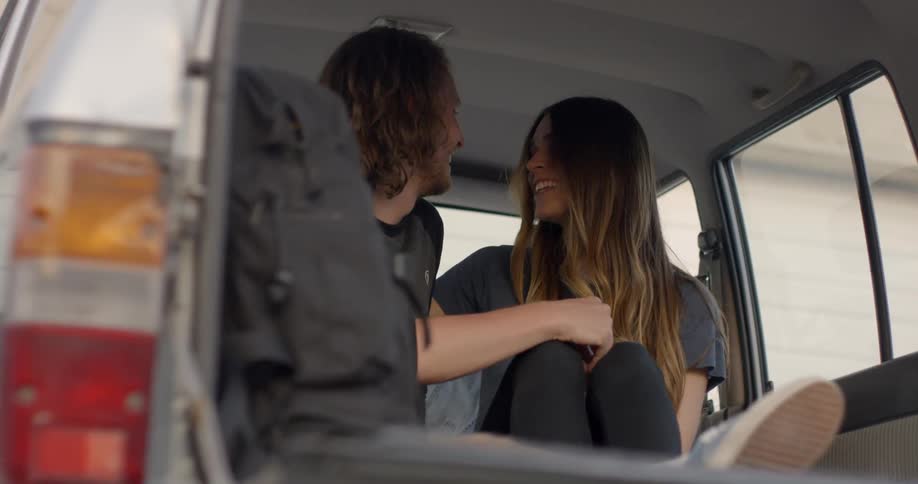 A couple sit talking in the back of the vehicle