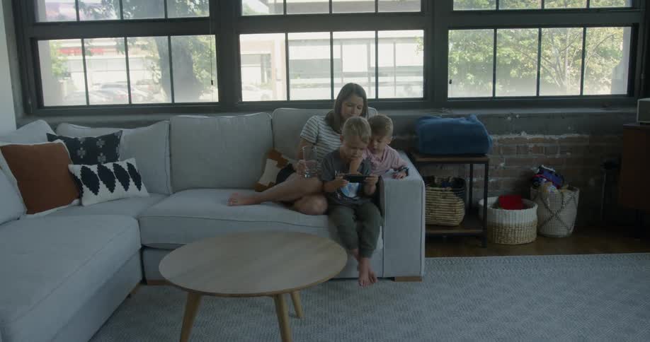 Woman sits on the couch with two boys