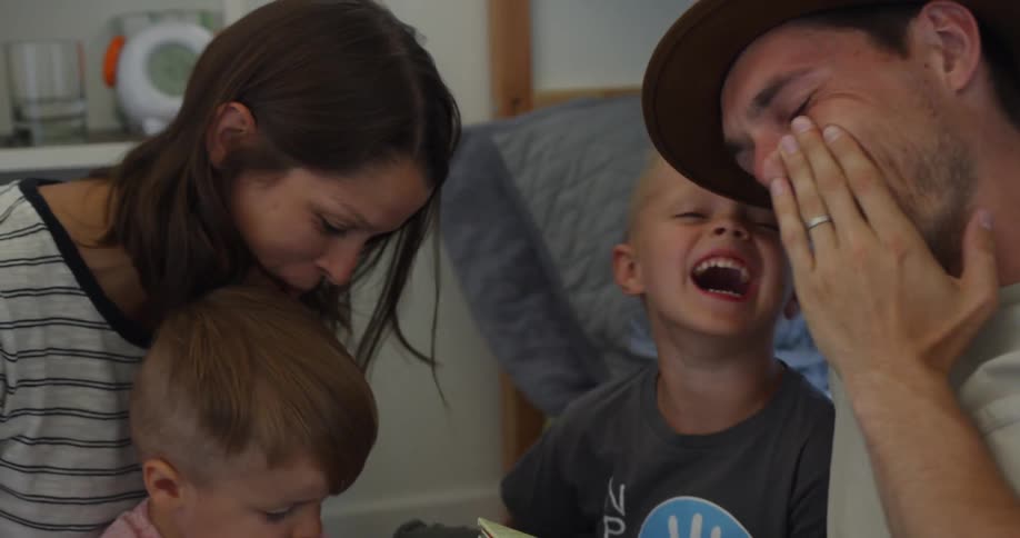 Man and woman laugh with two children