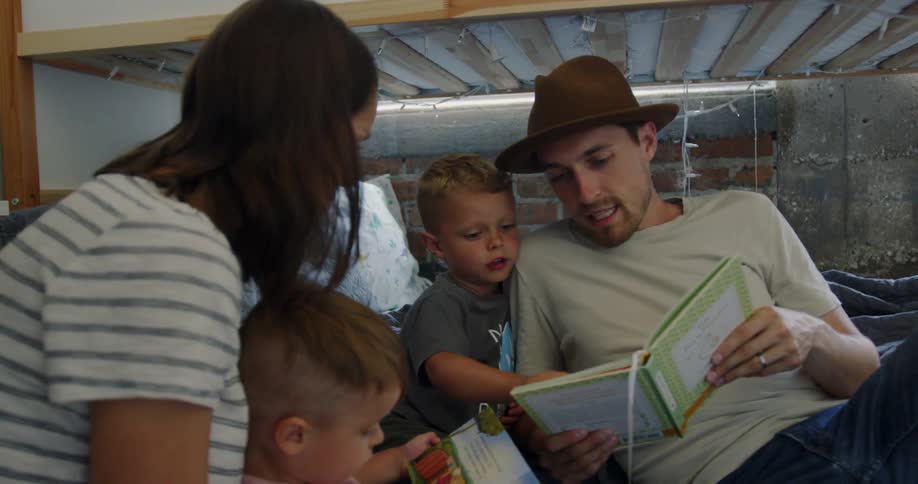 Man and woman and two small children read books