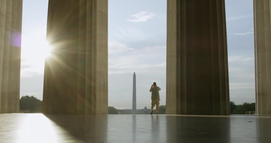 Man is taking picture of washington monument from lincoln memorial building