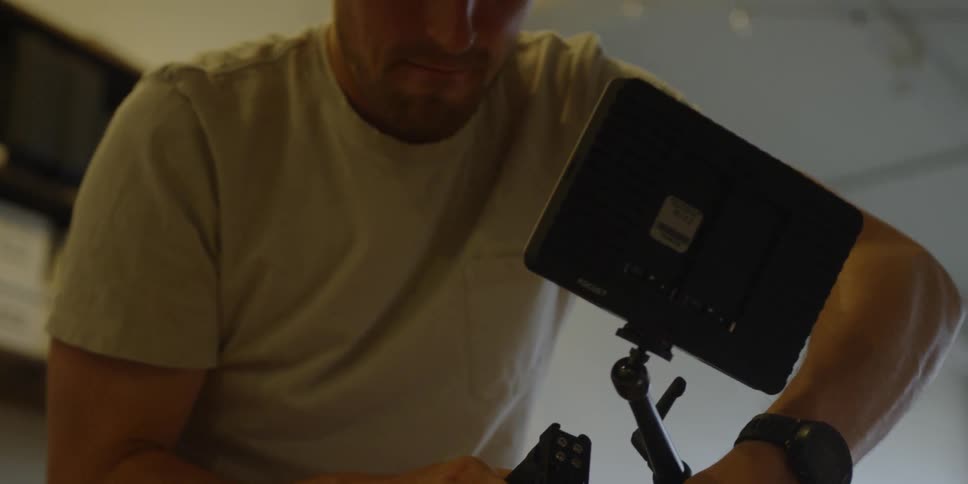 Man looks at the screen of a video camera