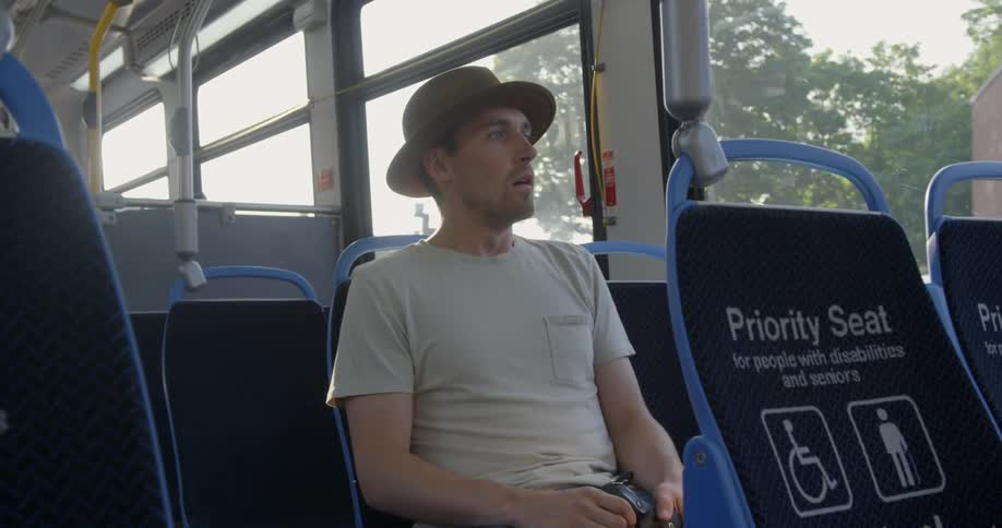 Man sits in a seat as he rides in the bus
