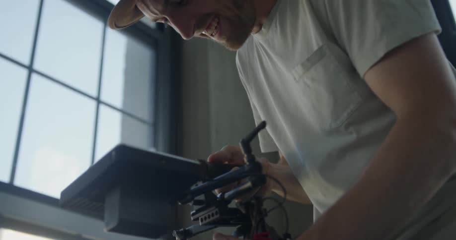 Man smiles as he adjusts the lens on an electronic device