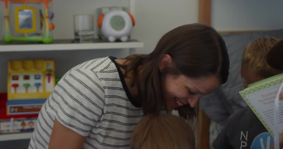 Parents laugh as they read to their kids