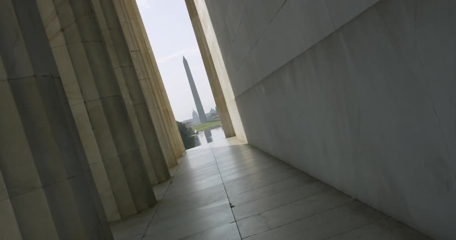 A rolling Washington monument frames by pillars of the Lincoln memorial